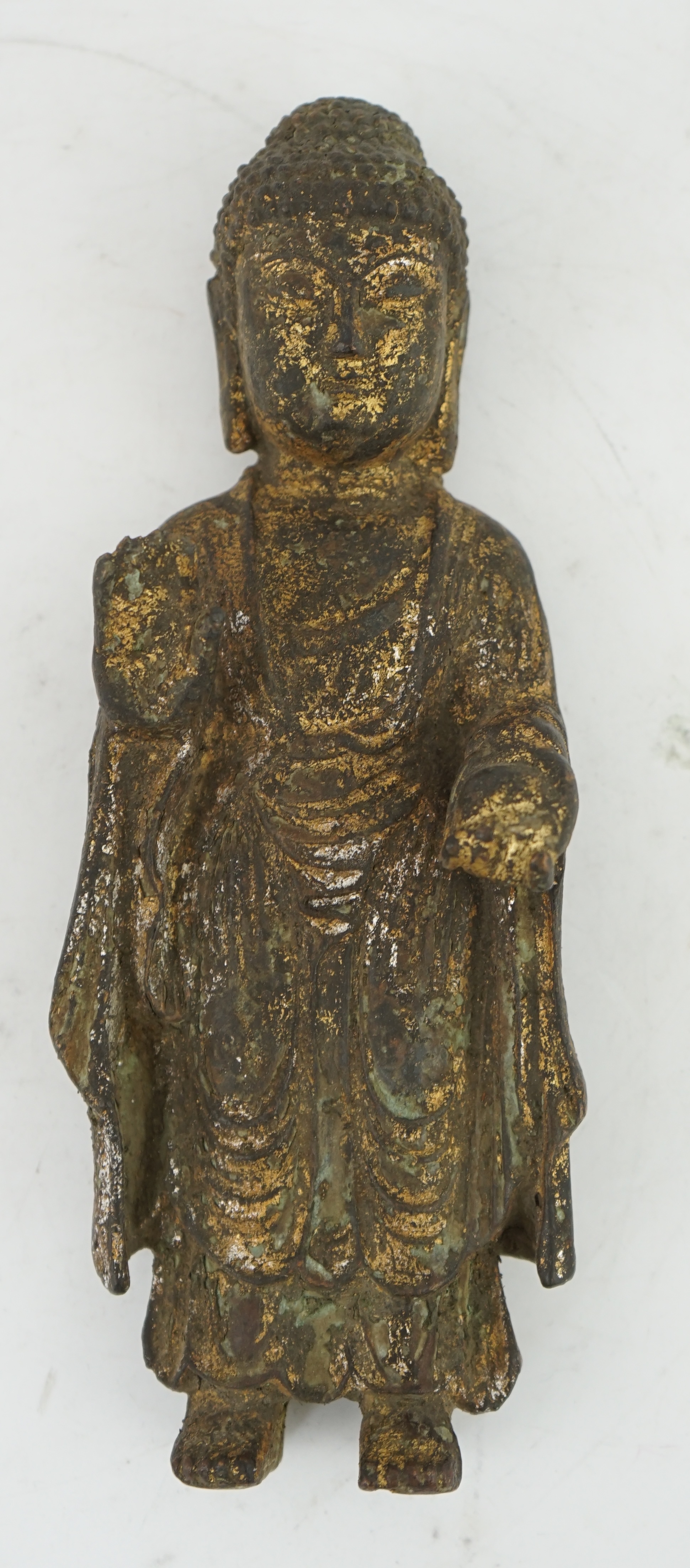 A Chinese gilt bronze model of a standing Buddha, 21.5cm. Condition - poor to fair